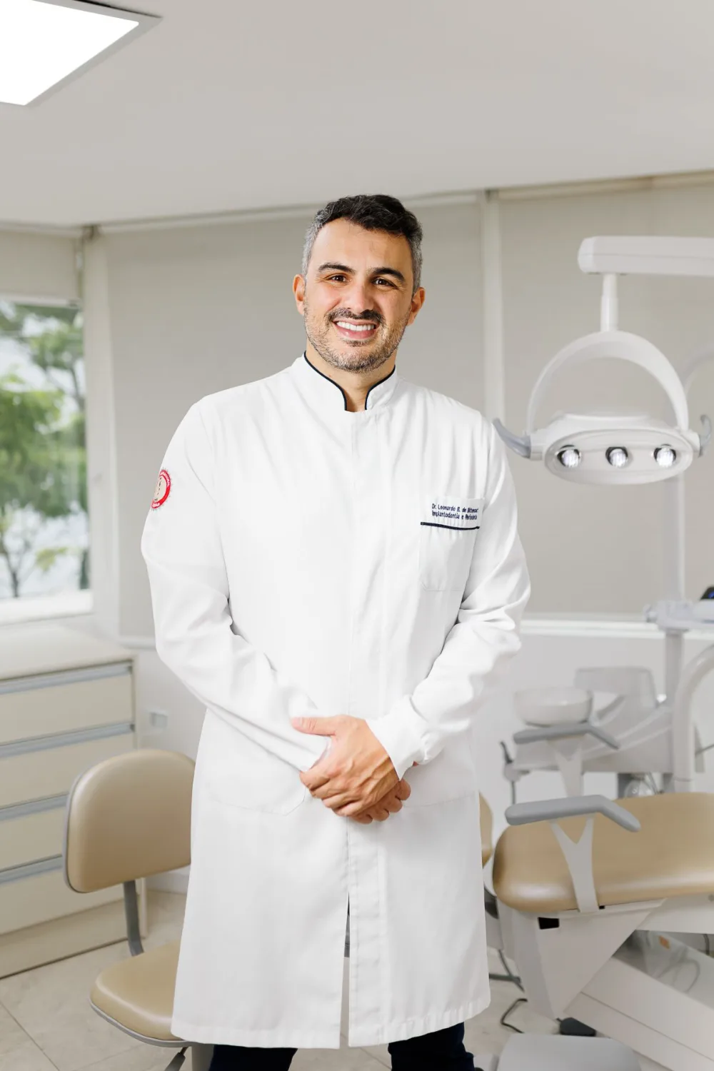 Dr. Leonardo Bellina em jaleco no consultório odontológico em Florianópolis